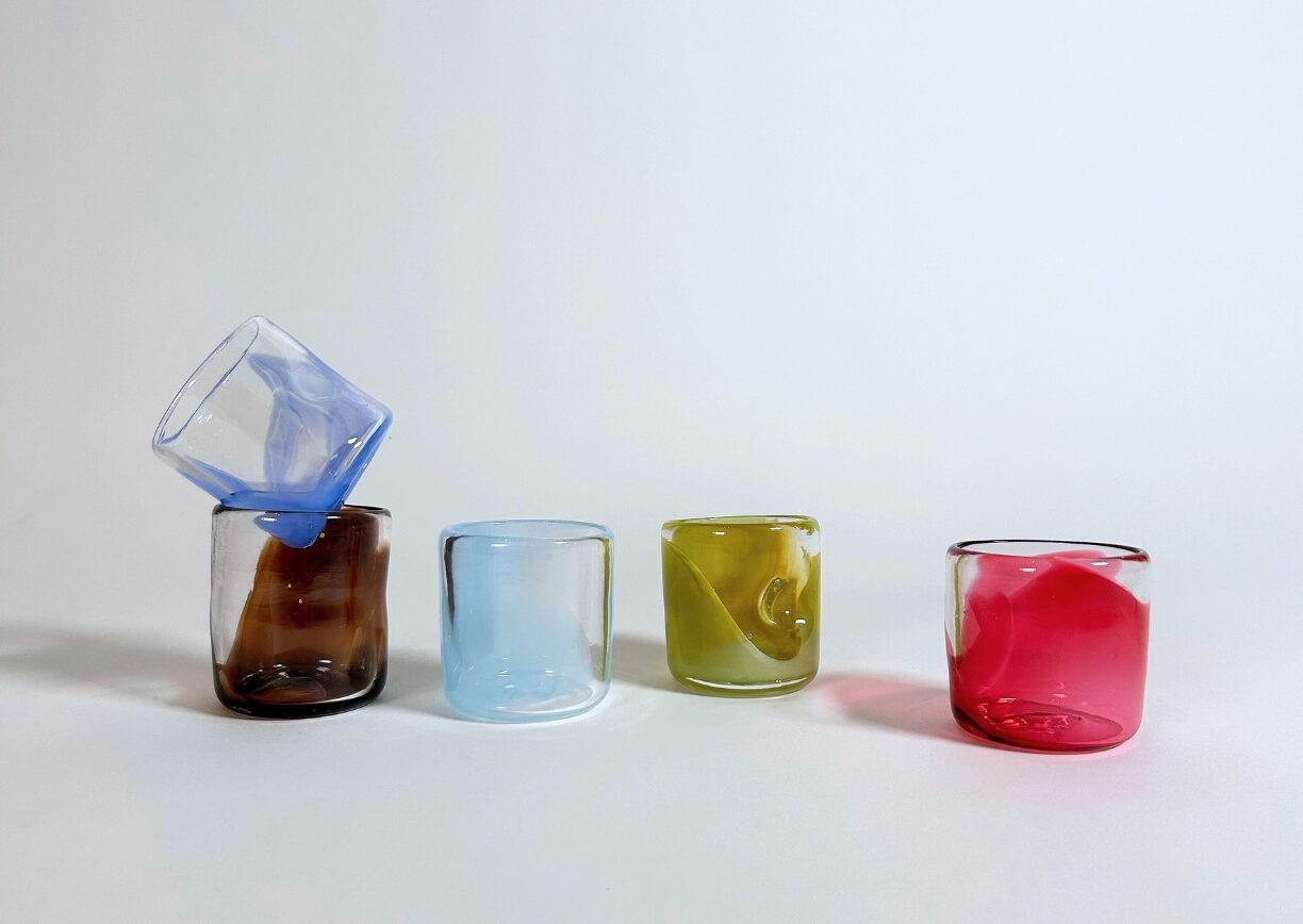 Tasses à espresso en verre soufflé coloré artisanal sur fond blanc, vue de face.