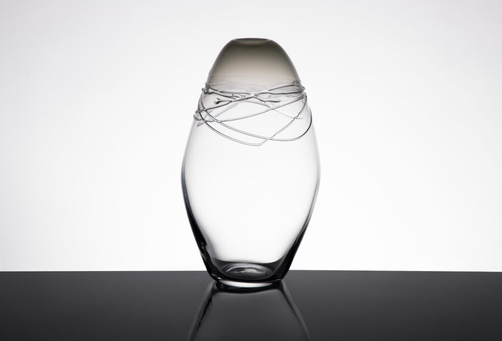 Vase avec cordon en verre soufflé transparent artisanale sur un fond blanc, vue de face.