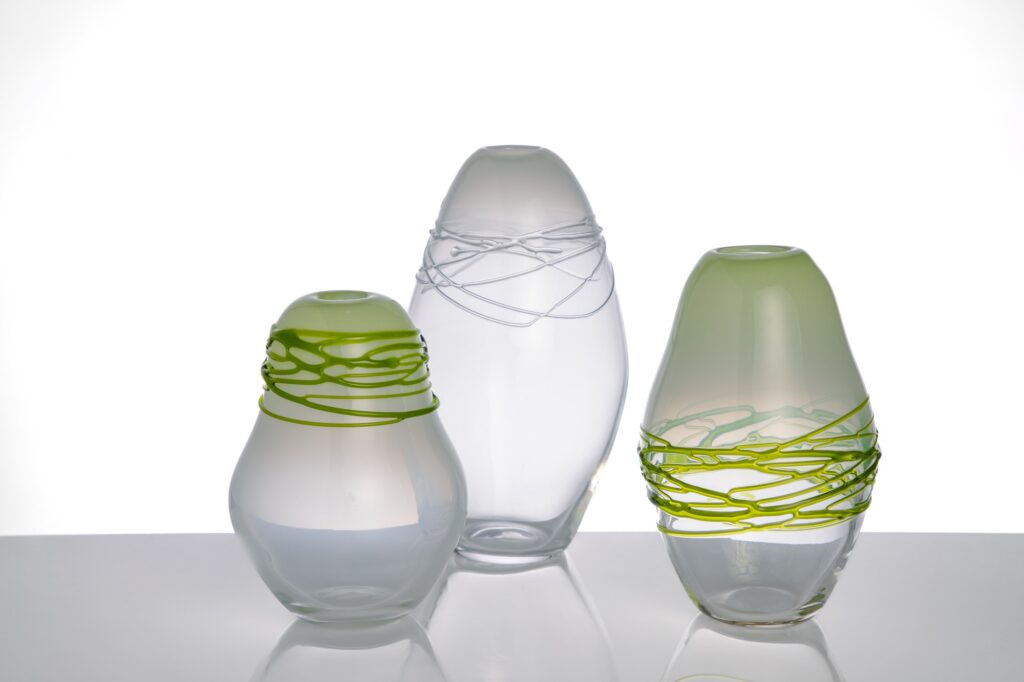 Vase avec cordon en verre soufflé artisanale, transparent et vert, sur un fond blanc, vue de face.